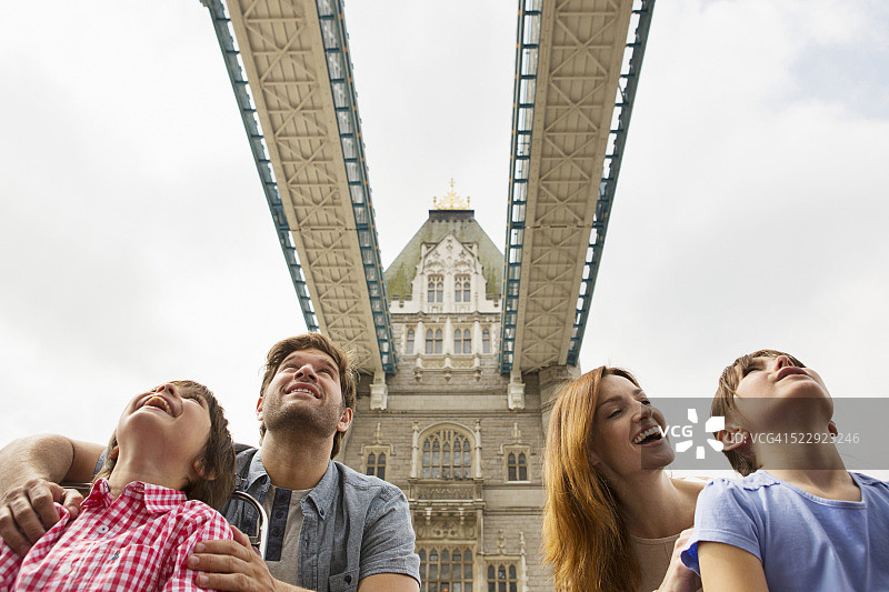 一家人和两个孩子（10-12岁）乘坐旅游巴士观看英国伦敦的塔桥图片素材