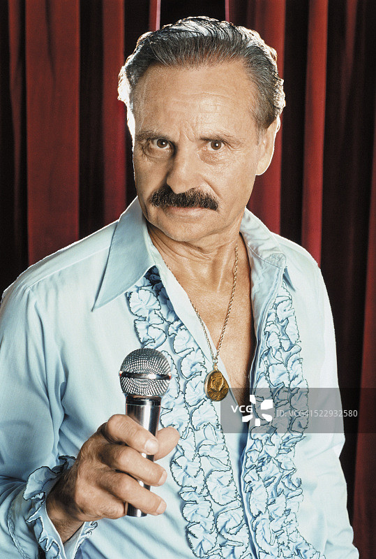 手持麦克风的年长歌手肖像图片素材