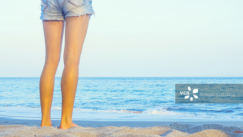 站在深蓝色大海前的美丽女孩的后视图图片素材