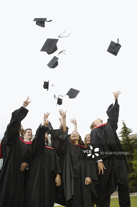 毕业生们将毕业帽抛向空中图片素材