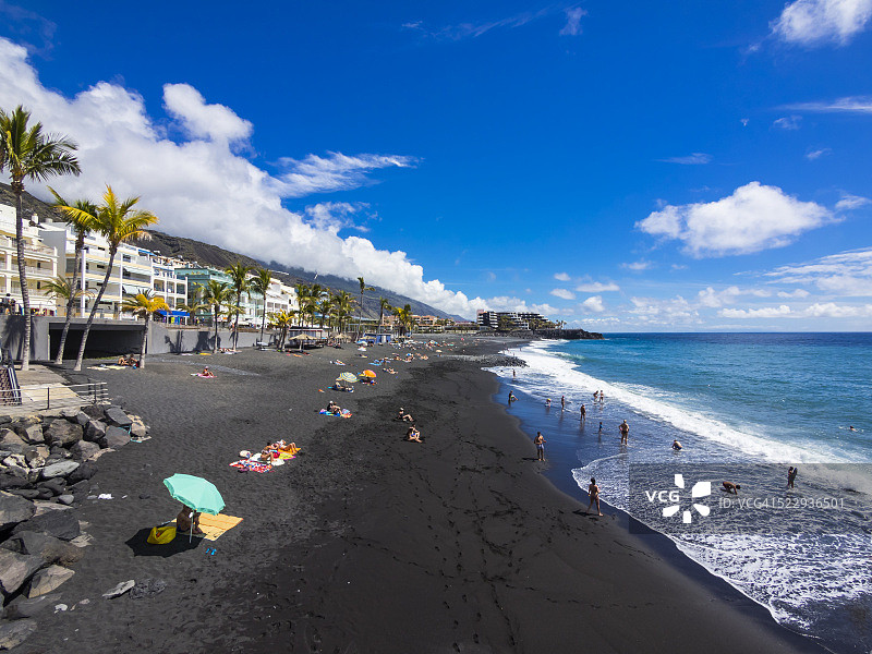 西班牙巴利阿里群岛纳奥斯港黑熔岩海滩上的游客图片素材