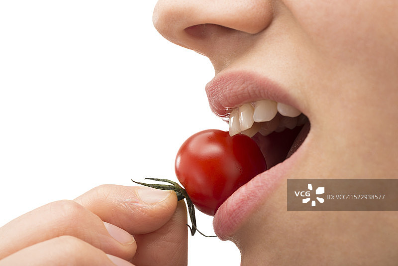 咬着樱桃番茄的女人图片素材