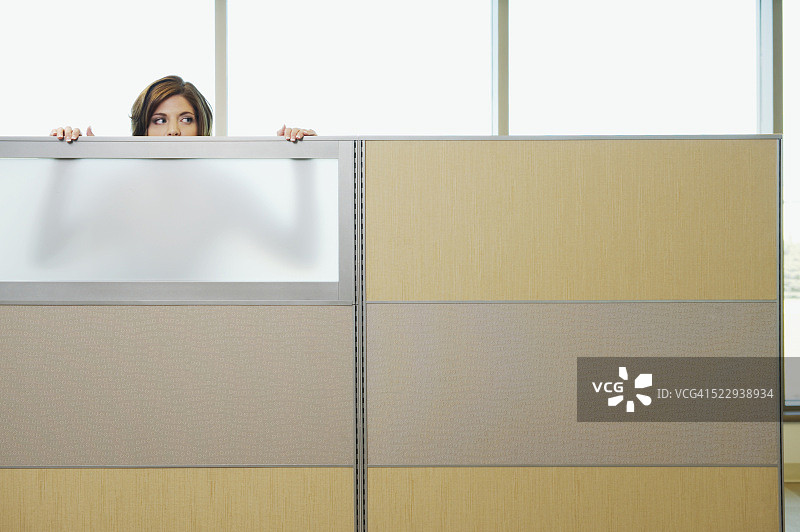 从隔间墙后窥视的女商人图片素材