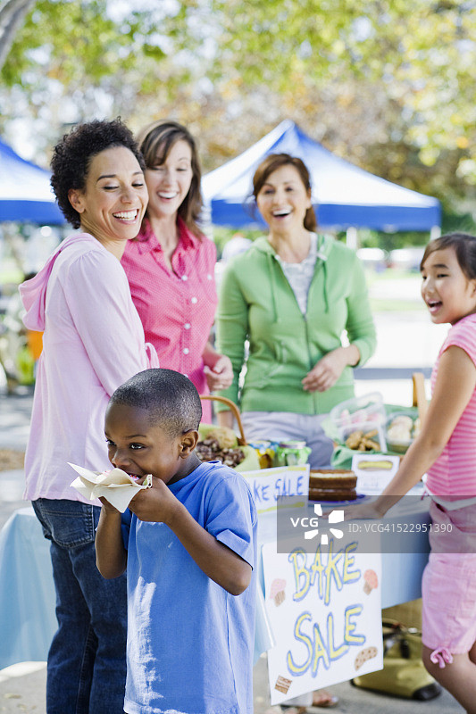 男孩在烘焙义卖会上吃东西图片素材