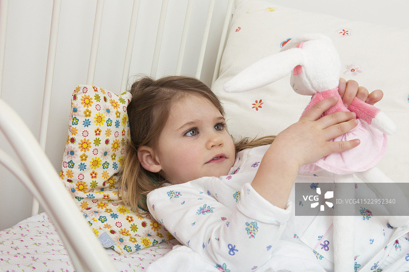 在床上玩毛绒玩具的女孩（2-3岁）图片素材