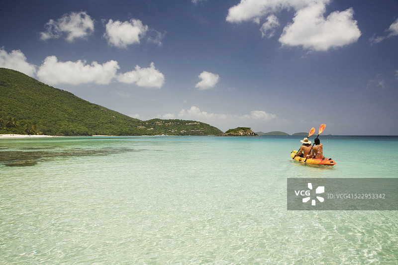 情侣在泻湖上划独木舟图片素材