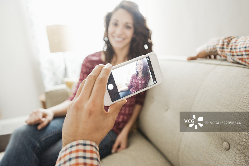 男子在沙发上给女友拍照图片素材