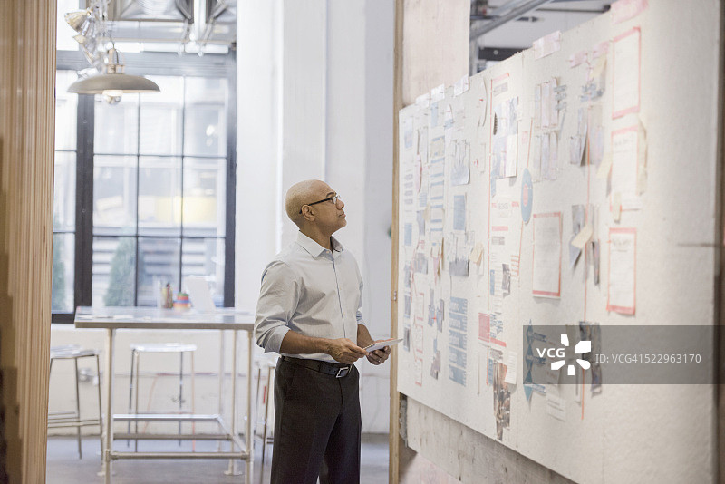 站在办公室里看着白板的商人图片素材