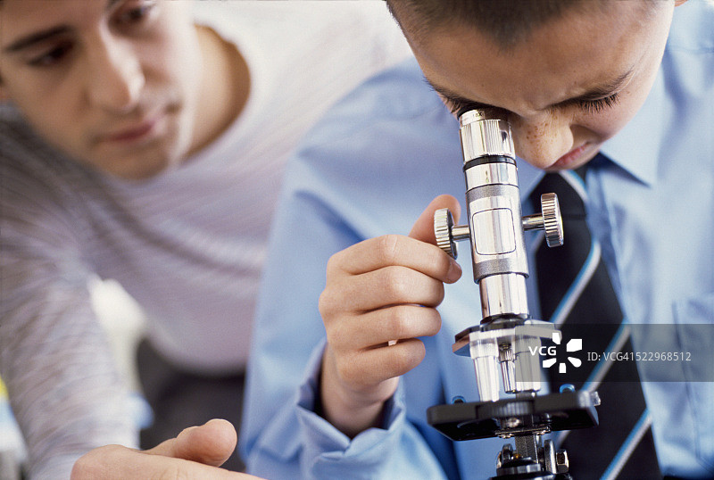 老师帮助学生使用显微镜图片素材