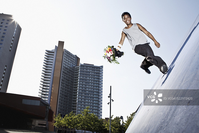 拿着花束做跑酷的青少年男孩图片素材
