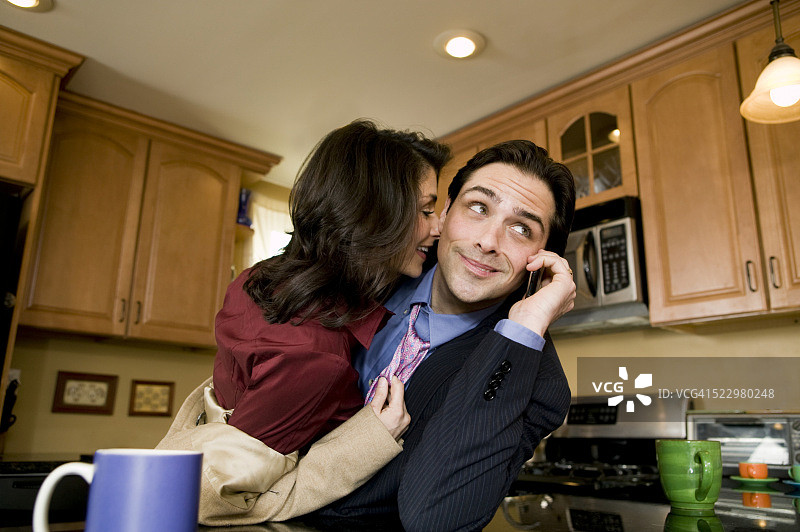 女人试图亲吻正在用手机的丈夫图片素材