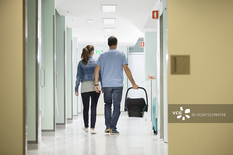 年轻夫妇带着婴儿提篮在医院的背影图片素材