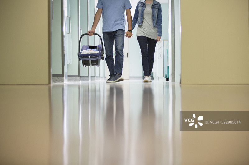 在医院走廊里抱着新生婴儿（0-1个月）的父母图片素材