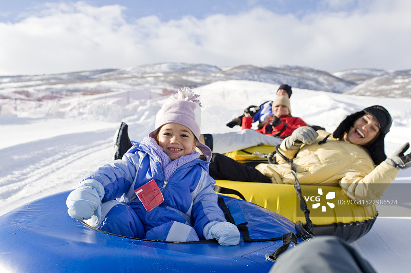 女孩和家人一起玩雪橇图片素材