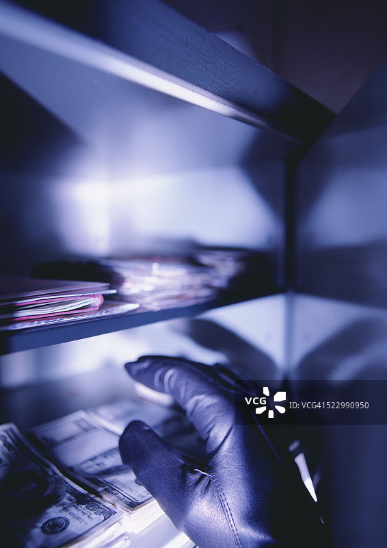 小偷从保险箱里偷钱图片素材