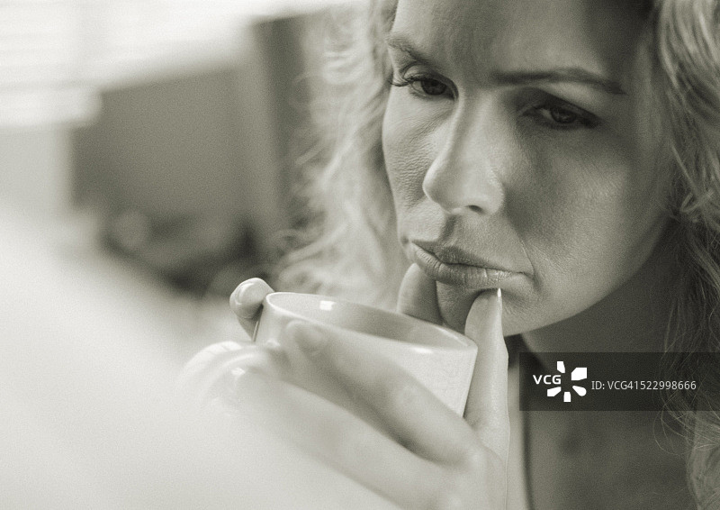 困惑的女人拿着咖啡杯图片素材