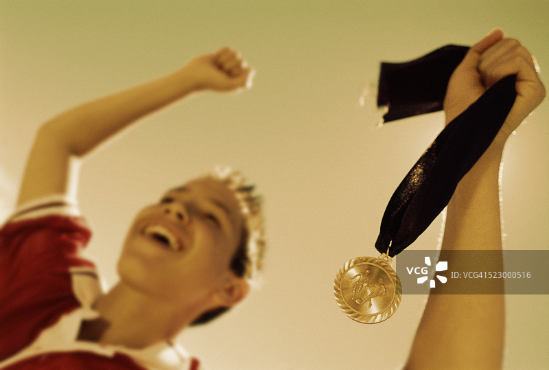 男孩抱着他的足球奖杯图片素材