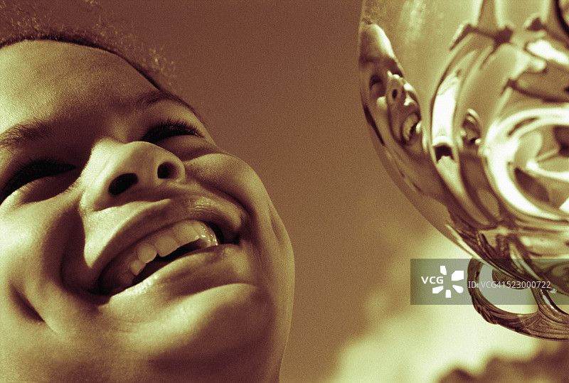 手持奖杯微笑的女孩图片素材