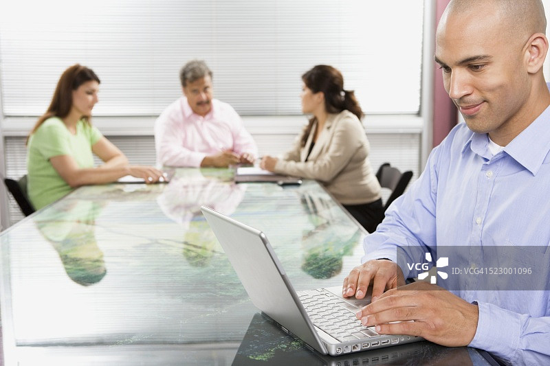 在会议室使用笔记本电脑的商人图片素材