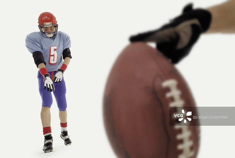 手持橄榄球，准备踢球图片素材