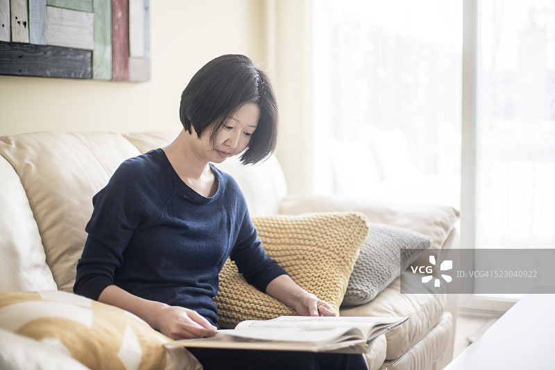 在客厅读书的韩国女人图片素材