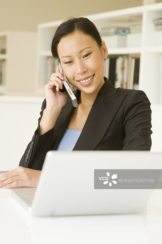 女商人使用笔记本电脑和手机图片素材