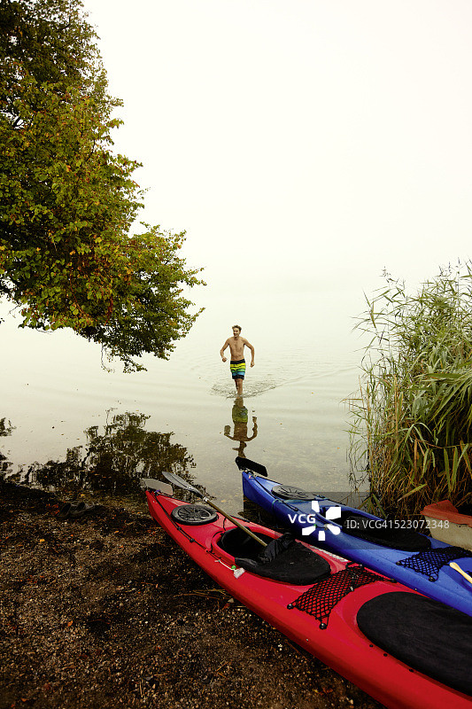 男人在德国巴伐利亚州施塔费尔湖中行走图片素材