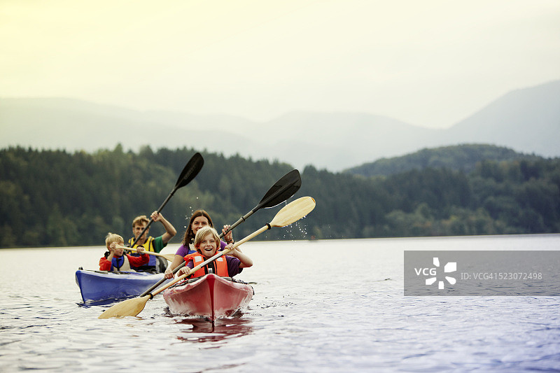 父母和儿子在德国巴伐利亚州施塔费尔湖上划独木舟图片素材