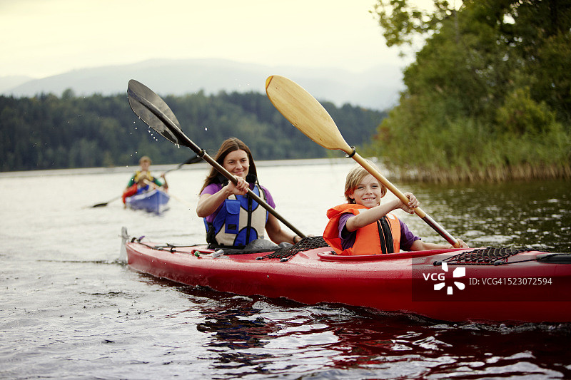 父母和儿子在德国巴伐利亚州施塔费尔湖上划独木舟图片素材
