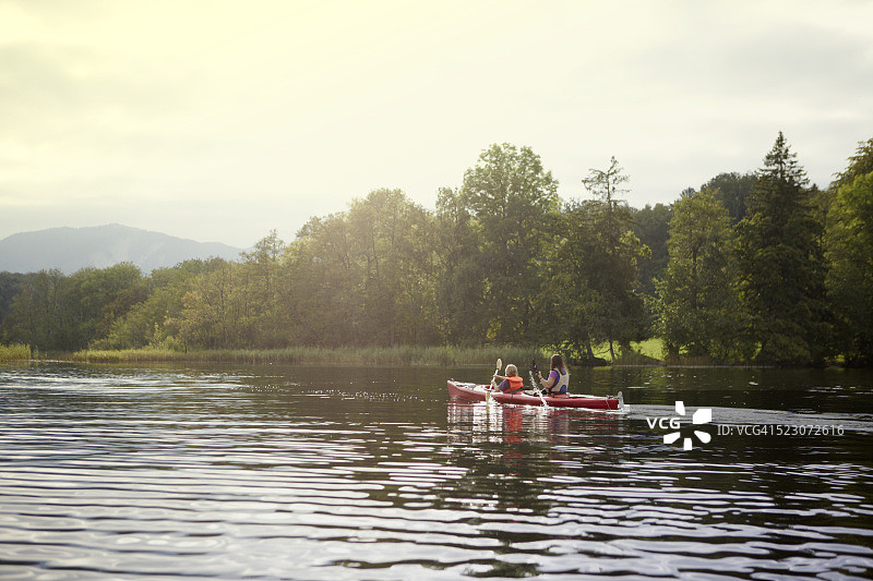 母亲和儿子（10-12岁）在德国巴伐利亚州施塔费尔湖上划独木舟图片素材