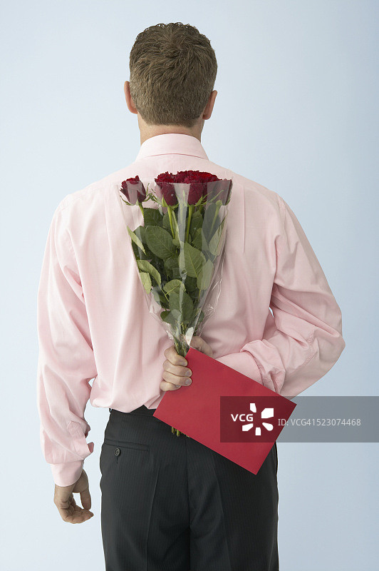 男人手持红玫瑰和卡片图片素材