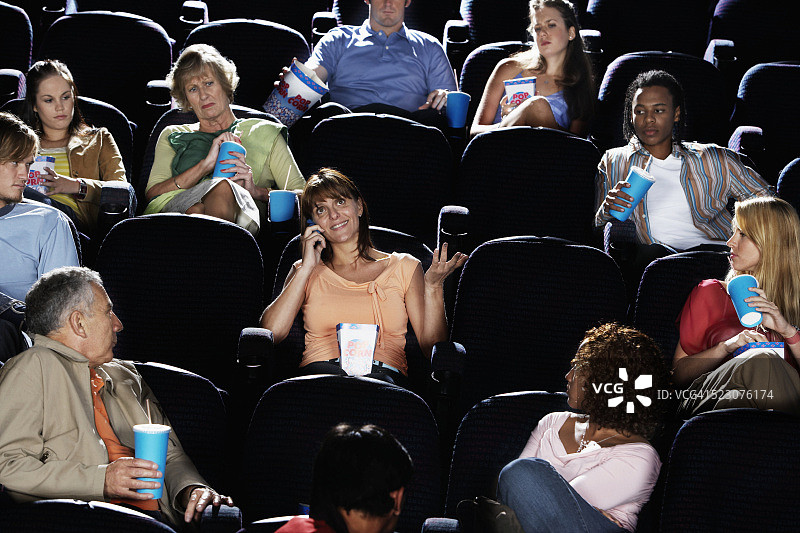 电影期间用手机交谈的女人图片素材