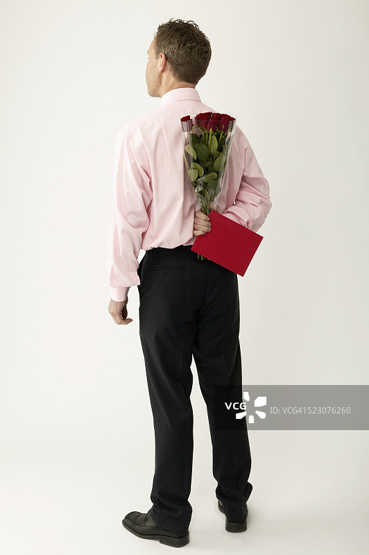 男人手持红玫瑰和卡片图片素材