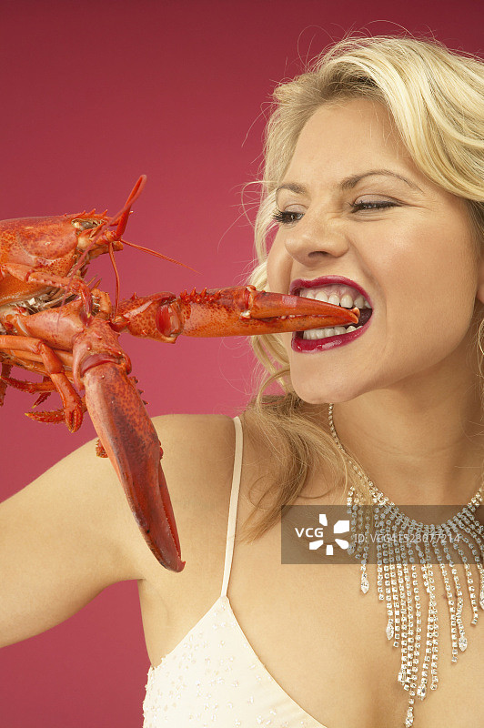 吃龙虾的富裕年轻女人图片素材