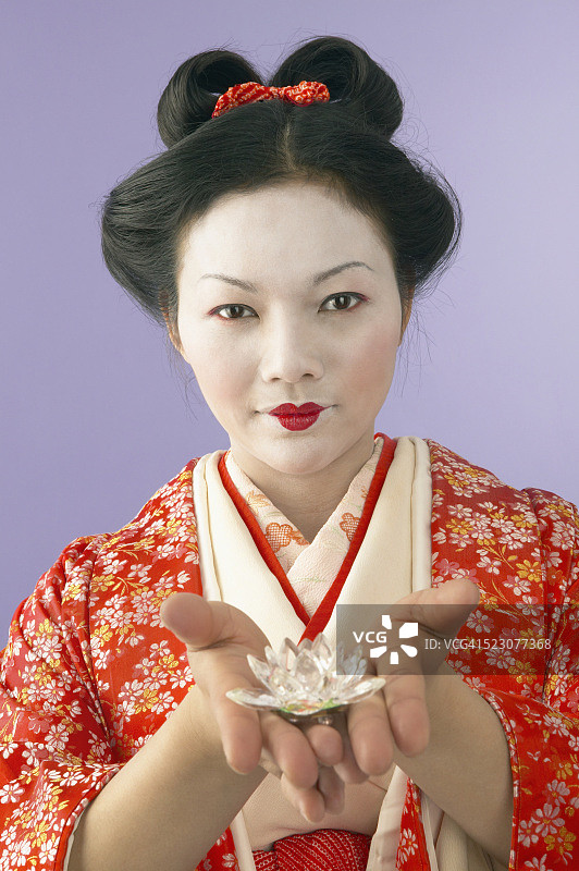 手持莲花胸针的艺伎图片素材