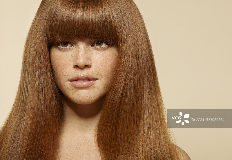 长棕色头发的年轻女性影棚肖像图片素材