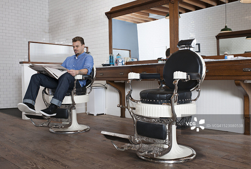 理发师看报纸等待顾客图片素材