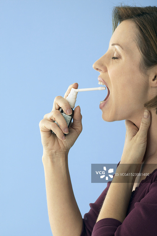 使用喉咙喷雾剂的女人图片素材