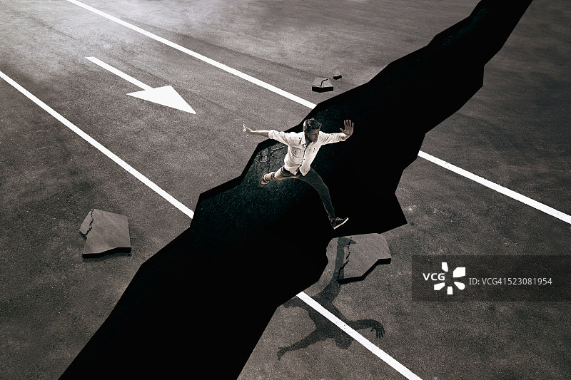 男人跳过路面裂缝图片素材
