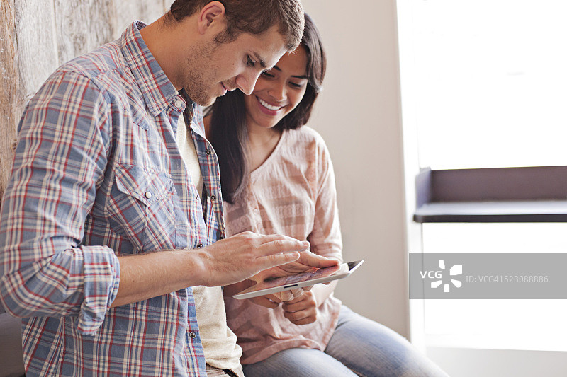 男人和女人在咖啡馆里使用平板电脑图片素材