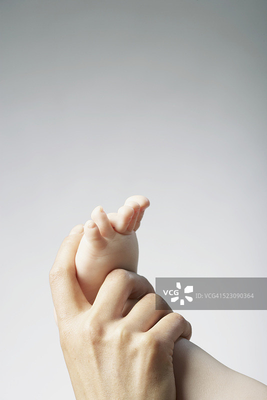 女子触摸婴儿的脚图片素材