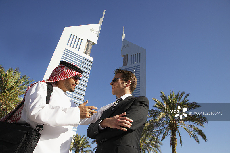 在阿联酋大厦下交谈的商人们图片素材