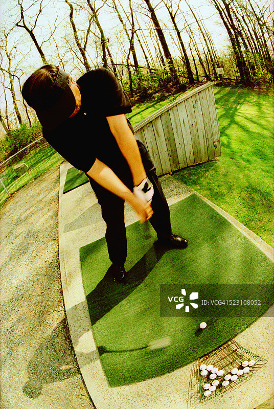 高尔夫球手在练习场开球图片素材