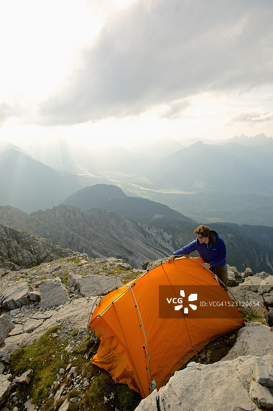男人在奥地利蒂罗尔山区搭建帐篷图片素材