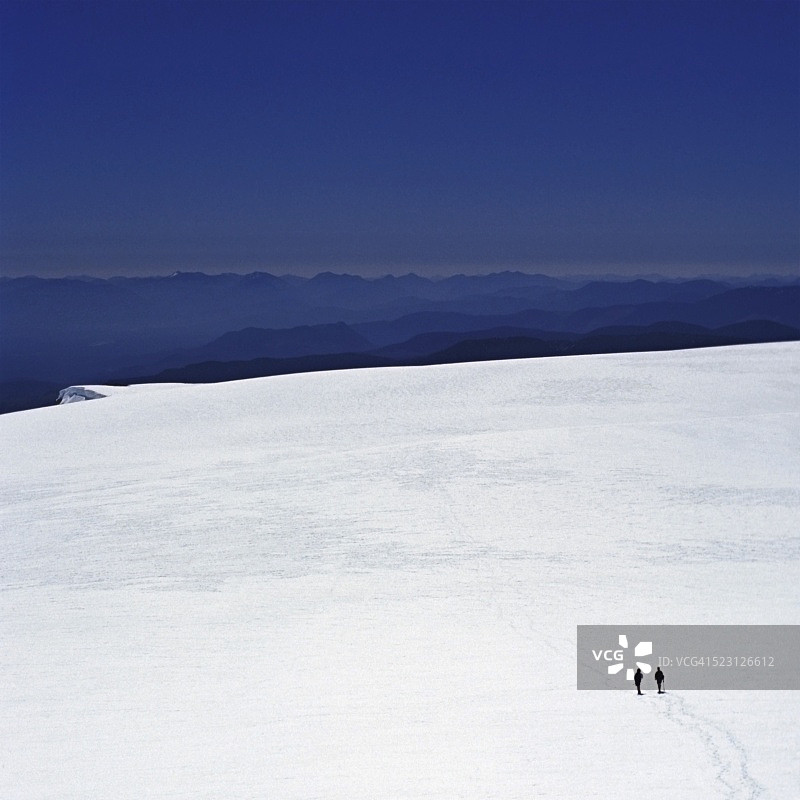 两位徒步者穿越加拿大不列颠哥伦比亚省斯特拉斯科纳公园的科莫克斯冰川图片素材