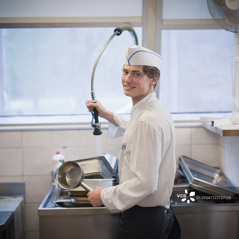 清洁平底锅的厨房工人图片素材