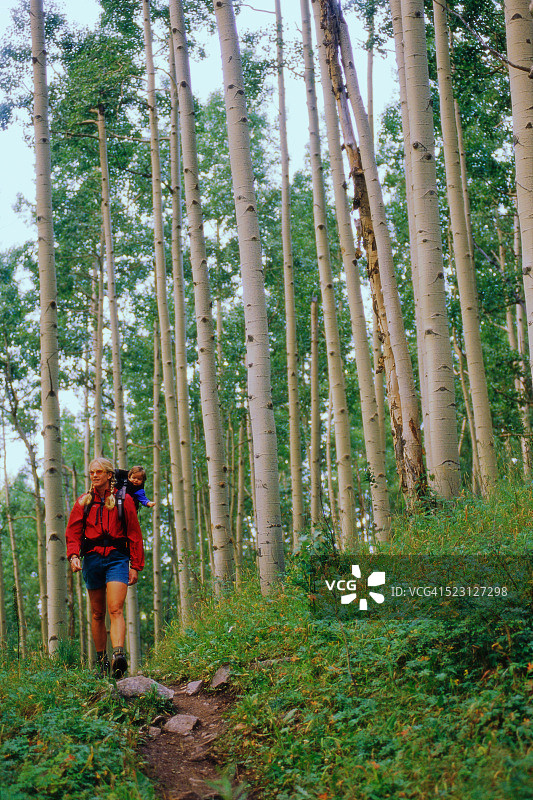 母亲和宝宝在树林里徒步旅行图片素材