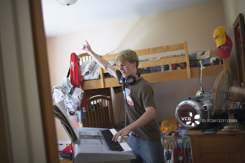 在卧室弹键盘的少年图片素材