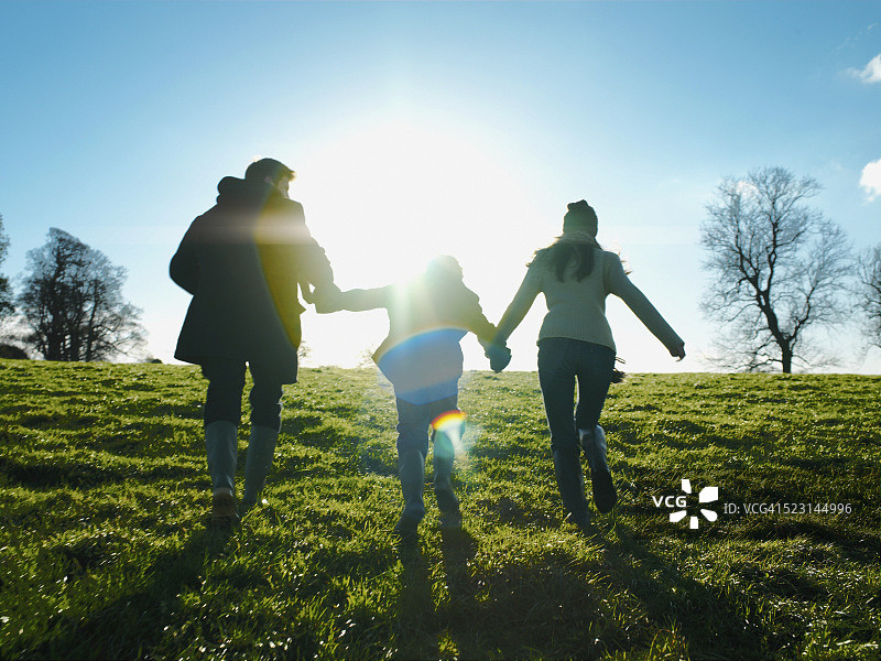 手牵手奔跑上山的家庭图片素材