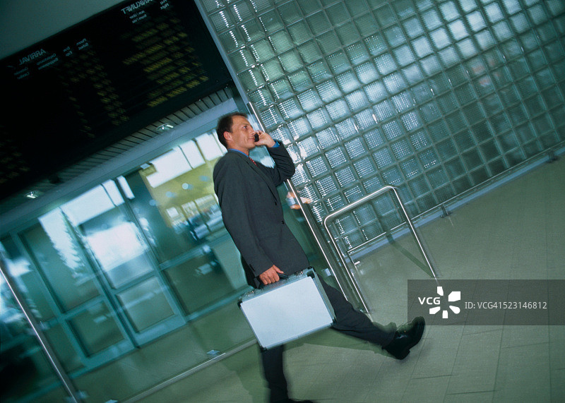 携带手机和公文包的商人图片素材